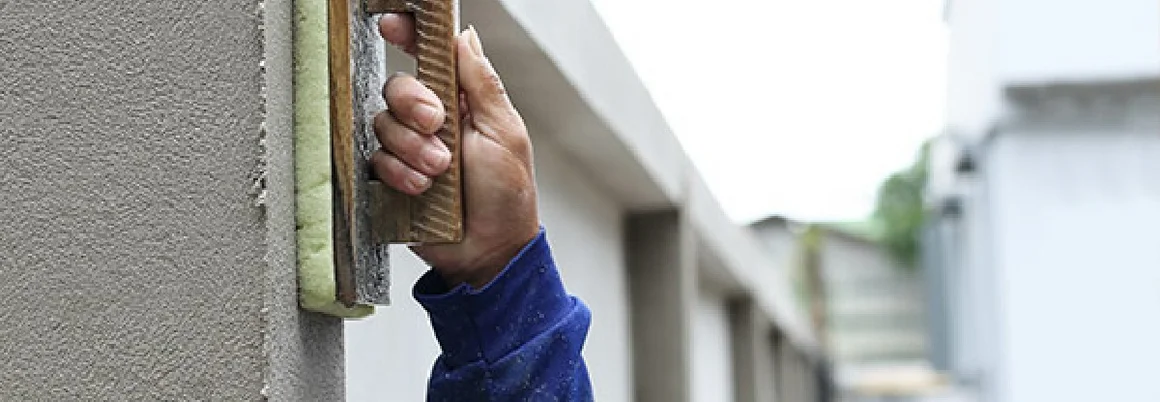 Person verputzt Wand mit Kelle